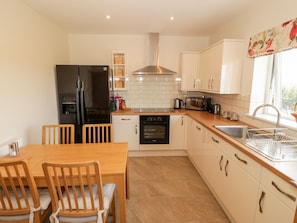 Enjoy cooking in this well-equipped kitchen with a central island, oven, and stainless steel range hood.