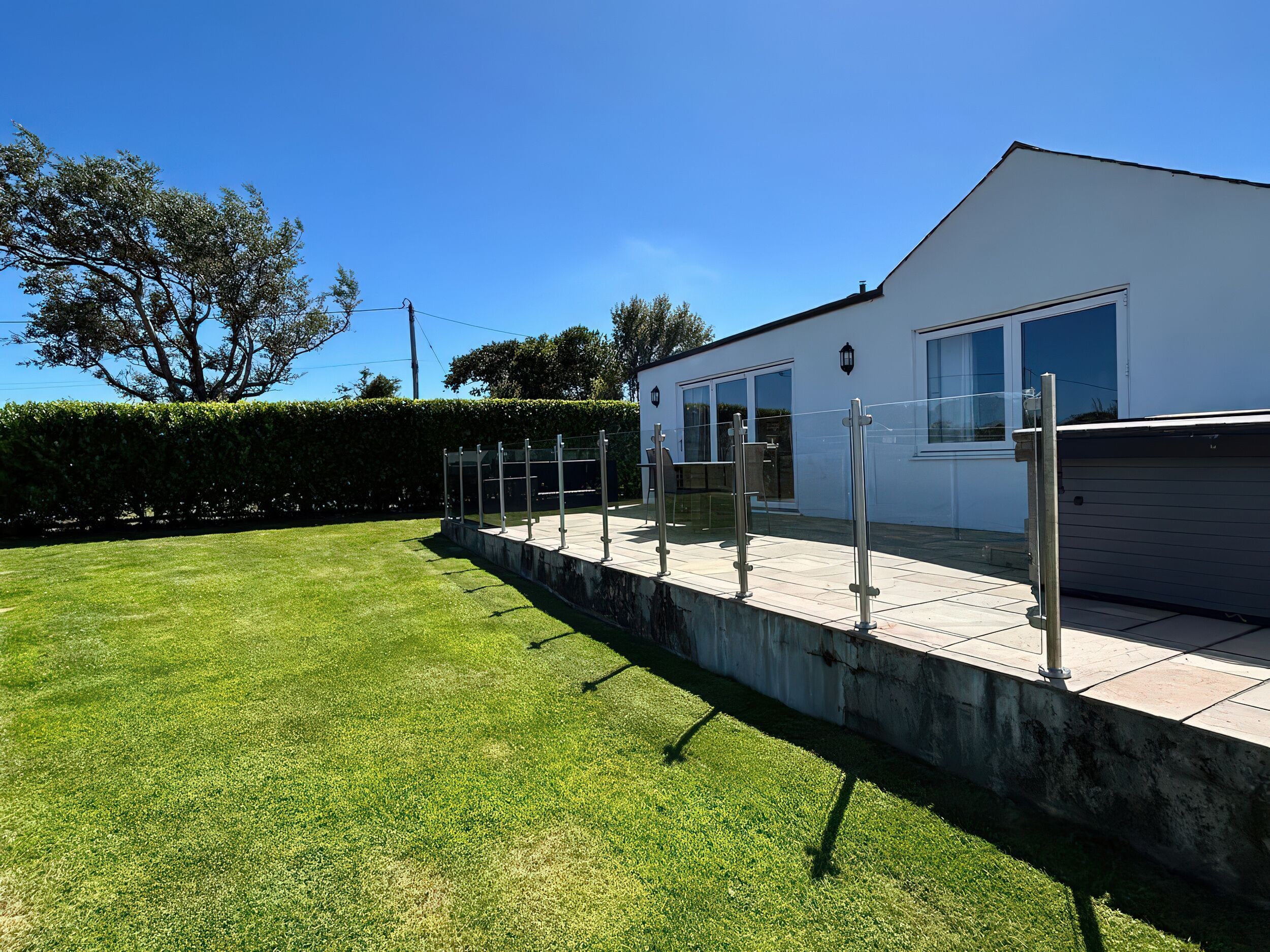 A modern building with a flat roof, large windows, and a paved patio area.