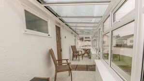 Ein Korridor mit einer Bank, Stühlen und einem Tisch.