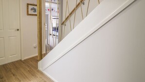 Eine Treppe mit einem hölzernen Geländer und einer weißen Wand.