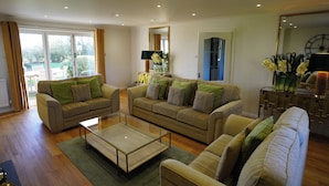 Ein geräumiges Wohnzimmer mit zwei Sofas, einem Couchtisch und einem großen Spiegel.