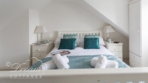 A neatly arranged bedroom with a bed, two bedside tables, and a wardrobe. - Ocean Swell (Weymouth)