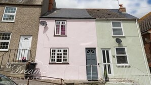 A two-story building with a pink and green facade, multiple windows, and satellite dishes. - Ocean Swell (Weymouth)