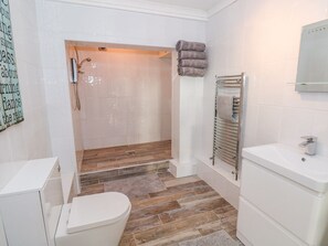 Une salle de bain avec douche, toilettes et lavabo.