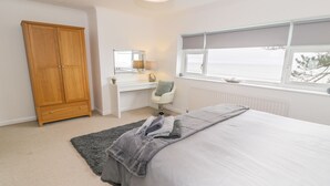 Una camera da letto con un letto, una scrivania, una sedia, un armadio e una finestra con vista.