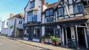 En traditionel bygning med et skilt, der viser 'The Puggle Coaching Inn', og angiver at det er et logi for rejsende.