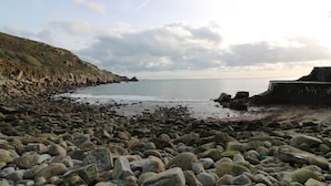 A rocky beach with a cliff and a calm sea. - Borah Lodge (Penzance)