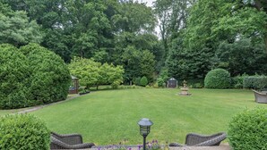 A well-maintained garden with a lawn, a gazebo, and wicker furniture. - Silvadale Cottage (Louth)