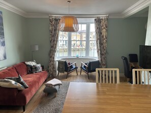 Relax in style with a comfortable sofa, dining table, and city views from the large window.