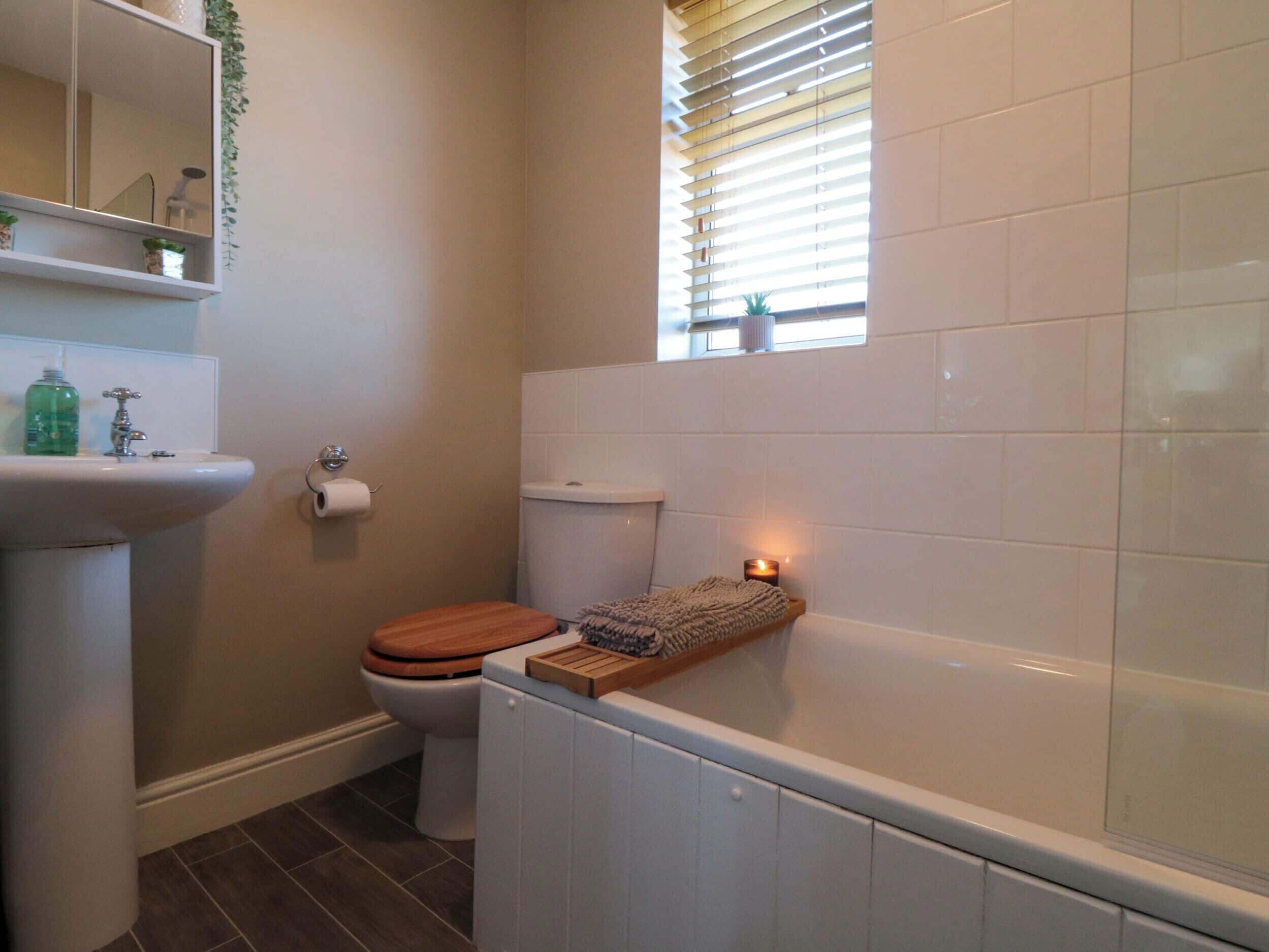 A bathroom with a toilet, sink, and bathtub.