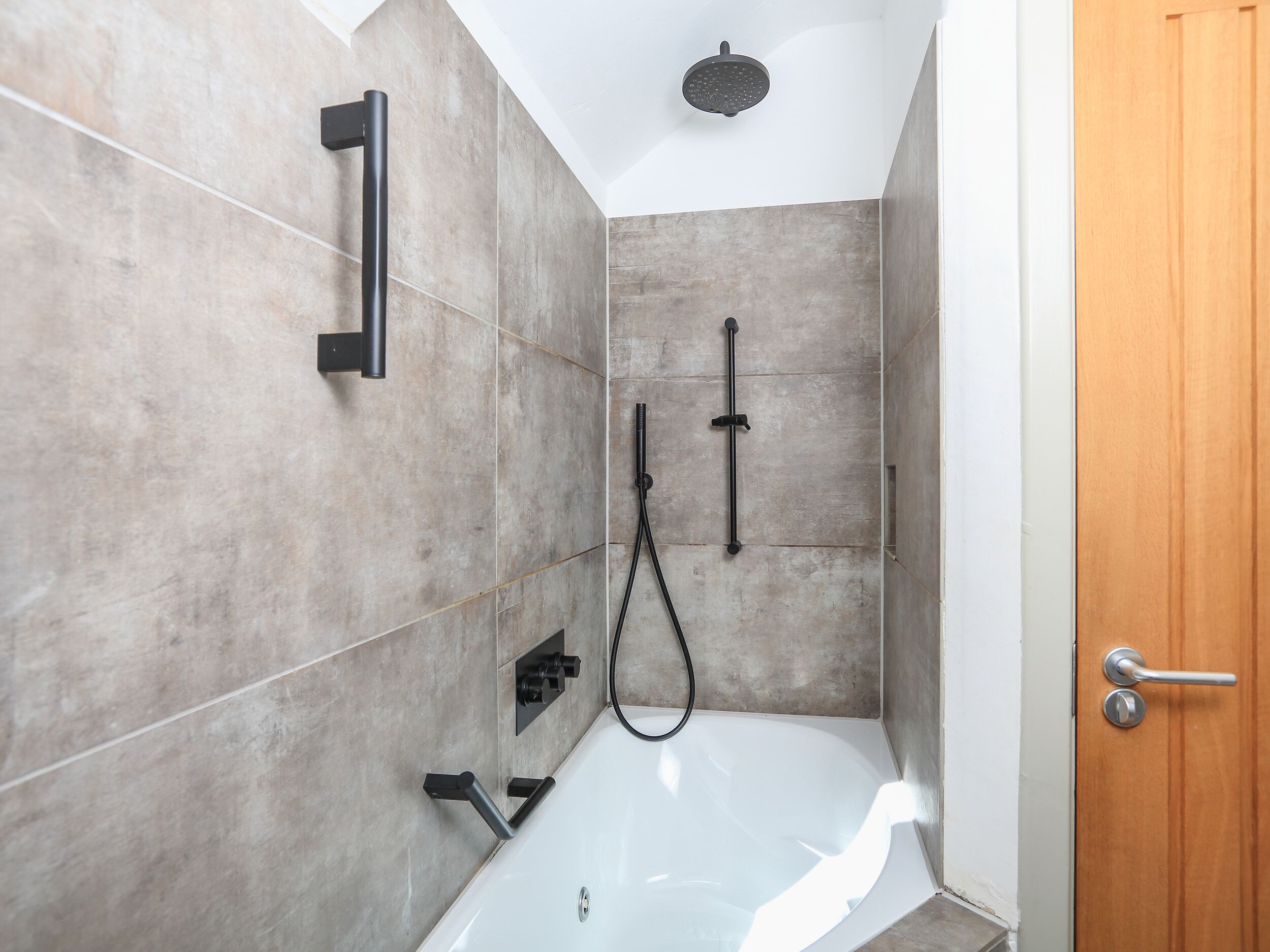 Un baño moderno con bañera, ducha y retrete.