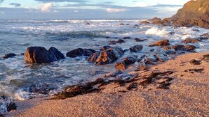 Una costa rocosa con olas rompiendo contra las rocas y piedras.