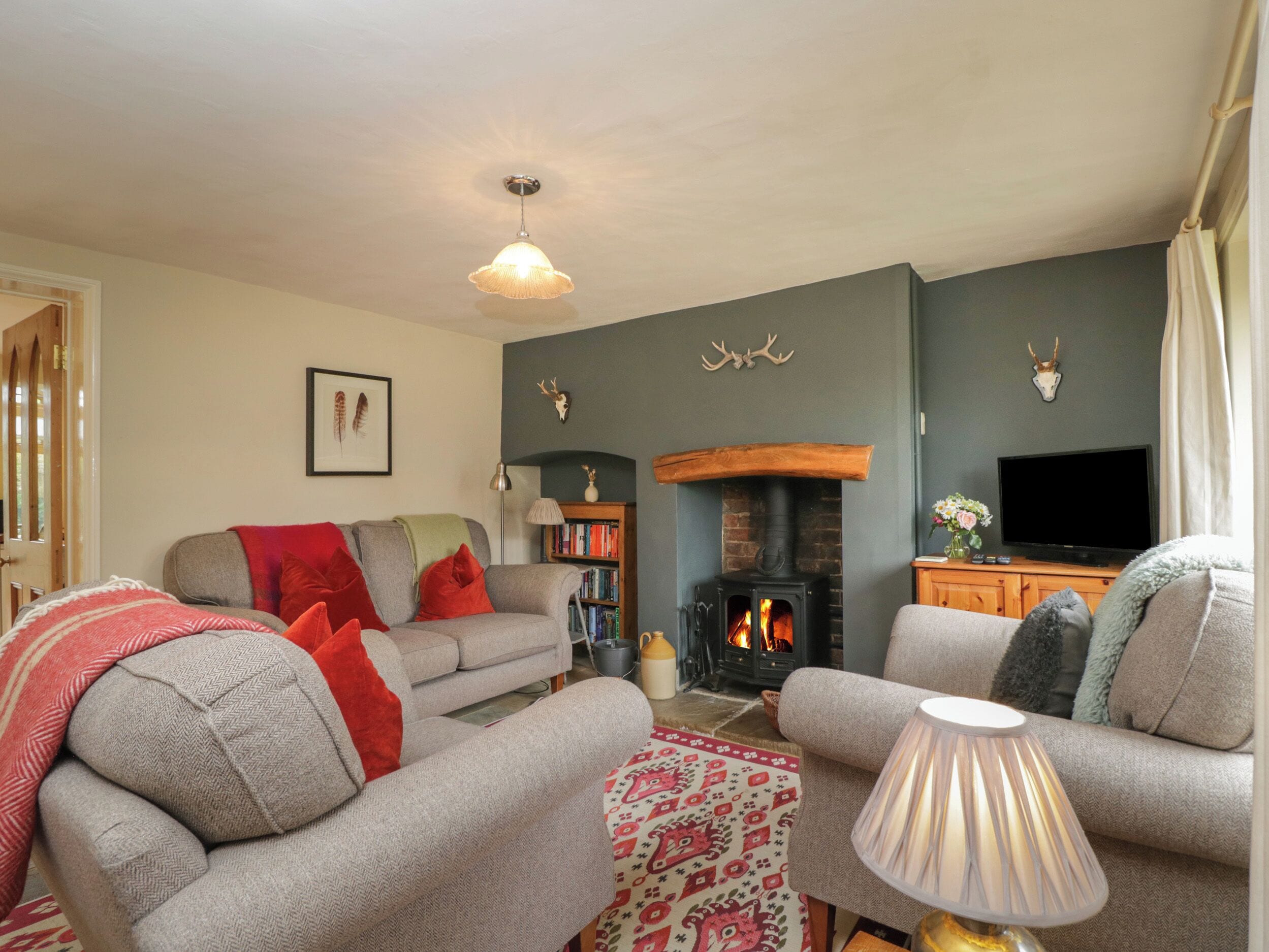 A cozy living room with a fireplace, sofas, and a television.