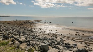 A rocky beach with a clear sky and calm sea.