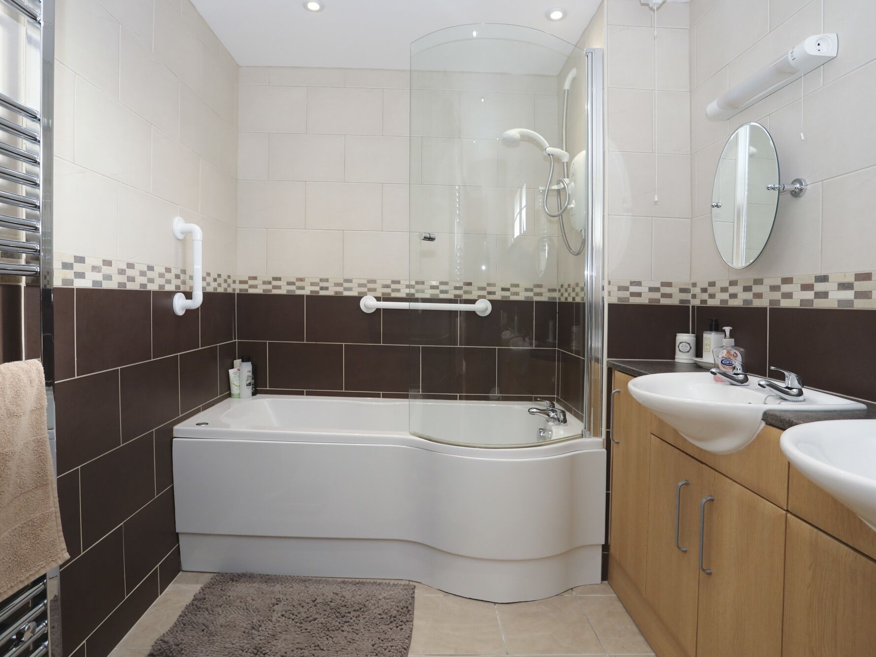 Een moderne badkamer met een bad, douche en wastafel.