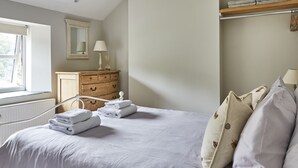Un dormitorio con cama, cómoda, espejo y ventana.