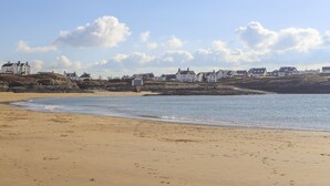 A coastal beach with houses in the background. - The Gables (Holyhead)