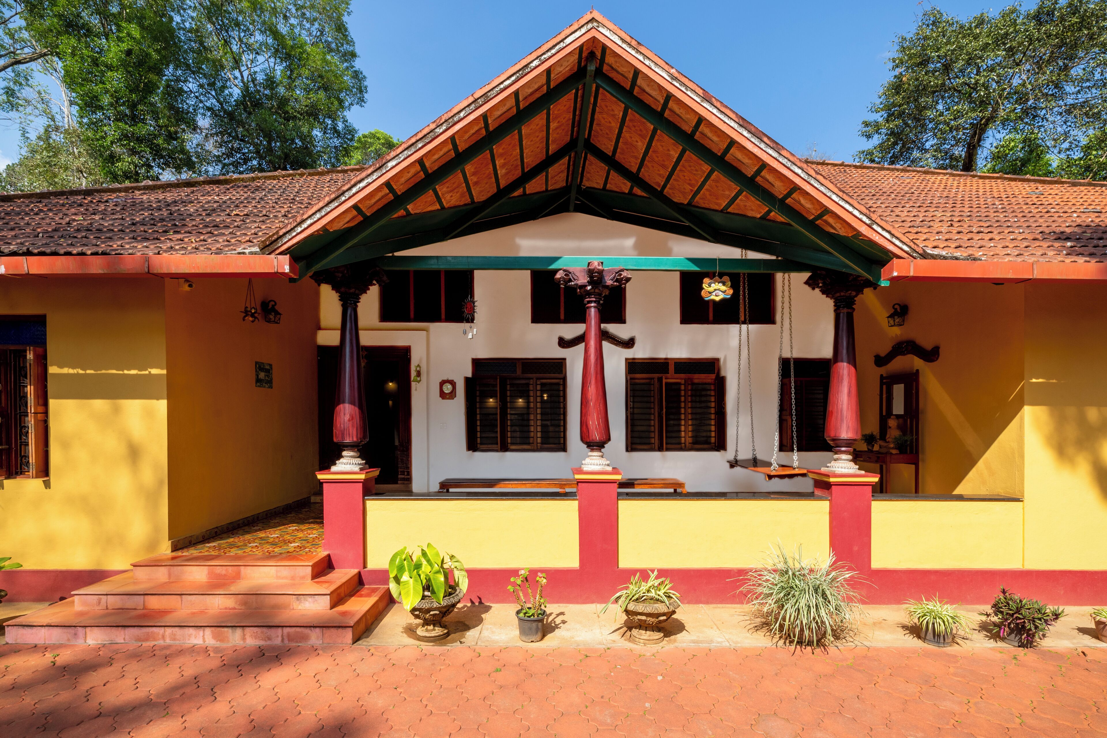 A traditional building with a tiled roof, a central porch with steps, and multiple windows.