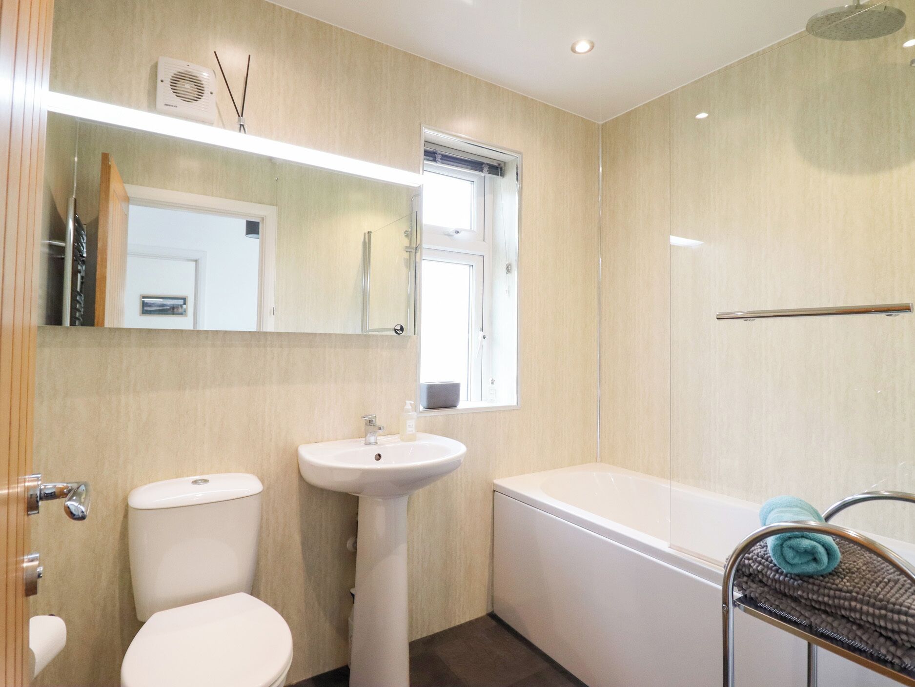 A modern bathroom with a toilet, sink, and bathtub.
