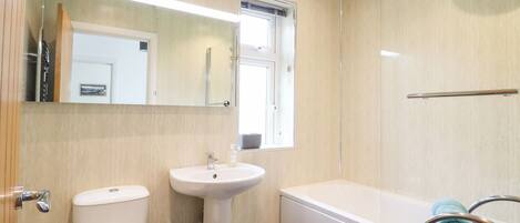 A modern bathroom with a toilet, sink, and bathtub.