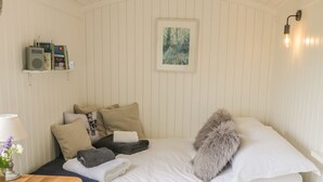 A neatly arranged bedroom with a bed, pillows, a bedside table with a lamp, and a framed picture on the wall. - Bellwether (York)