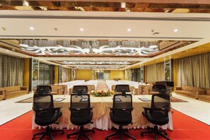 Une salle de conférence dotée d’une longue table, de nombreuses chaises et d’un plafond décoratif.