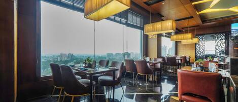 Un comedor moderno con vistas a la ciudad a través de amplios ventanales.