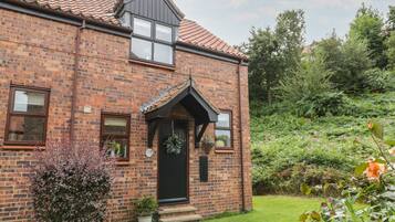 Traditional home with a charming front porch and beautifully manicured lawn.