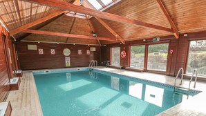 An indoor swimming pool with wooden beams and a tiled floor. - Fauna's Corner (Whitby)