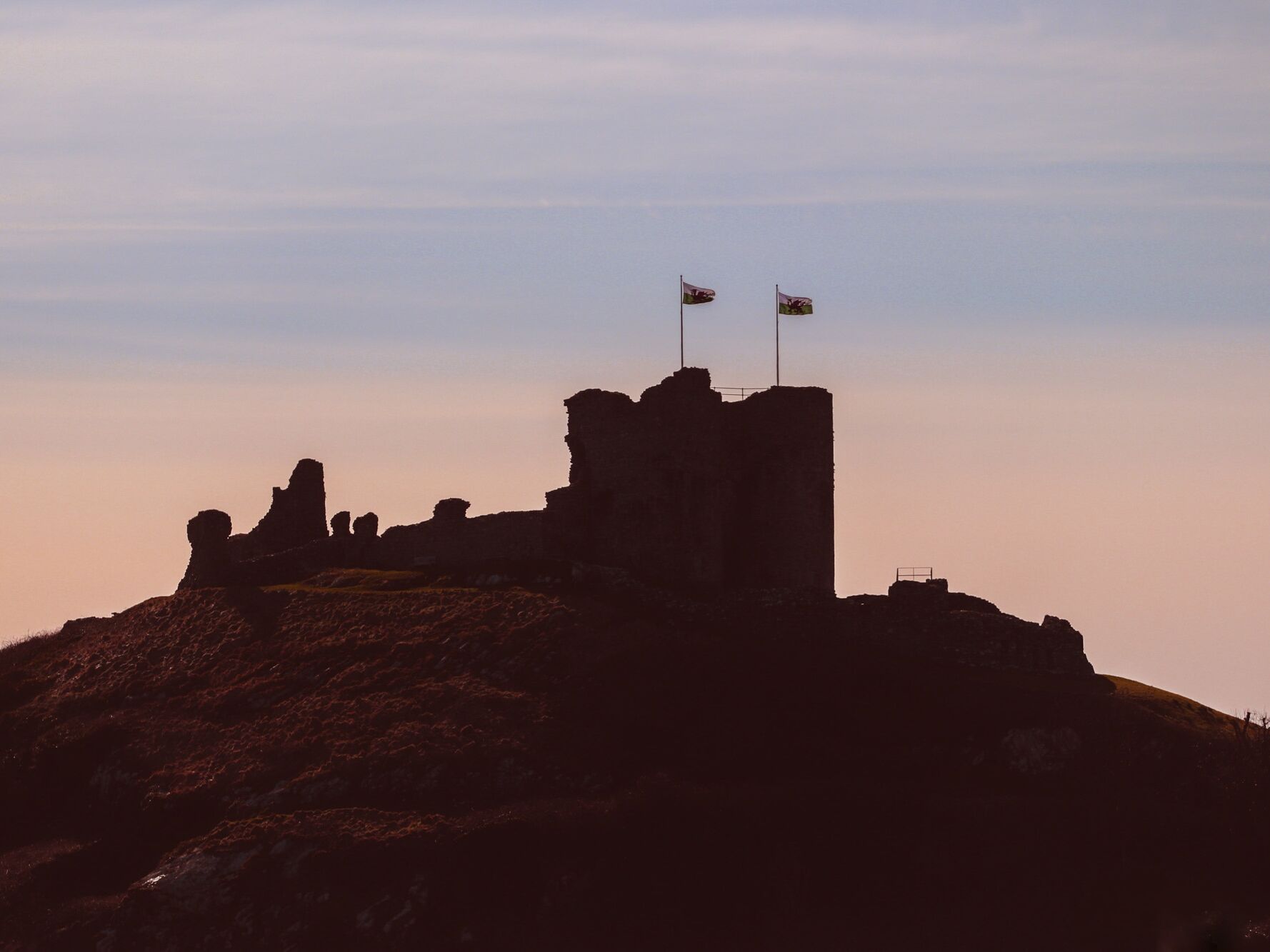 A castle-like structure with two flags on top, surrounded by rocky terrain.