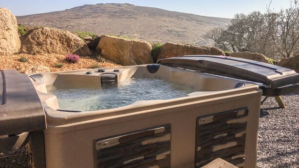 A hot tub with a view of a mountain in the background. - Brimpts Cottage (Yelverton)