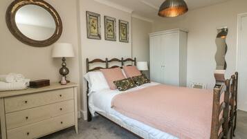 Un dormitorio con cama, cómoda, espejo y armario.