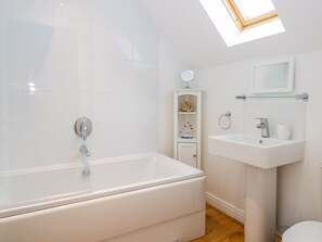 A modern bathroom with a freestanding bathtub, a sink, and a mirror.