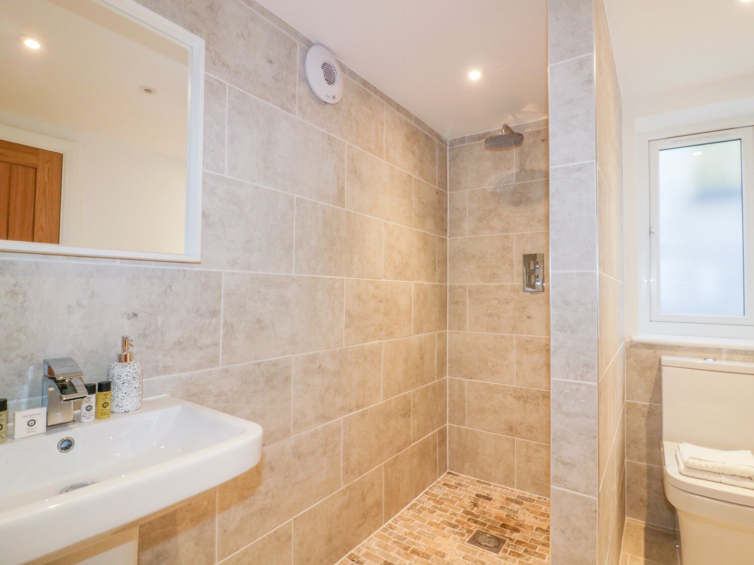 A bathroom with a shower, a sink, and a toilet.