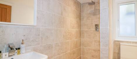 A bathroom with a shower, a sink, and a toilet.