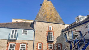 Un edificio con fachada de piedra, una chimenea azul y un cartel que indica prohibido estacionar.