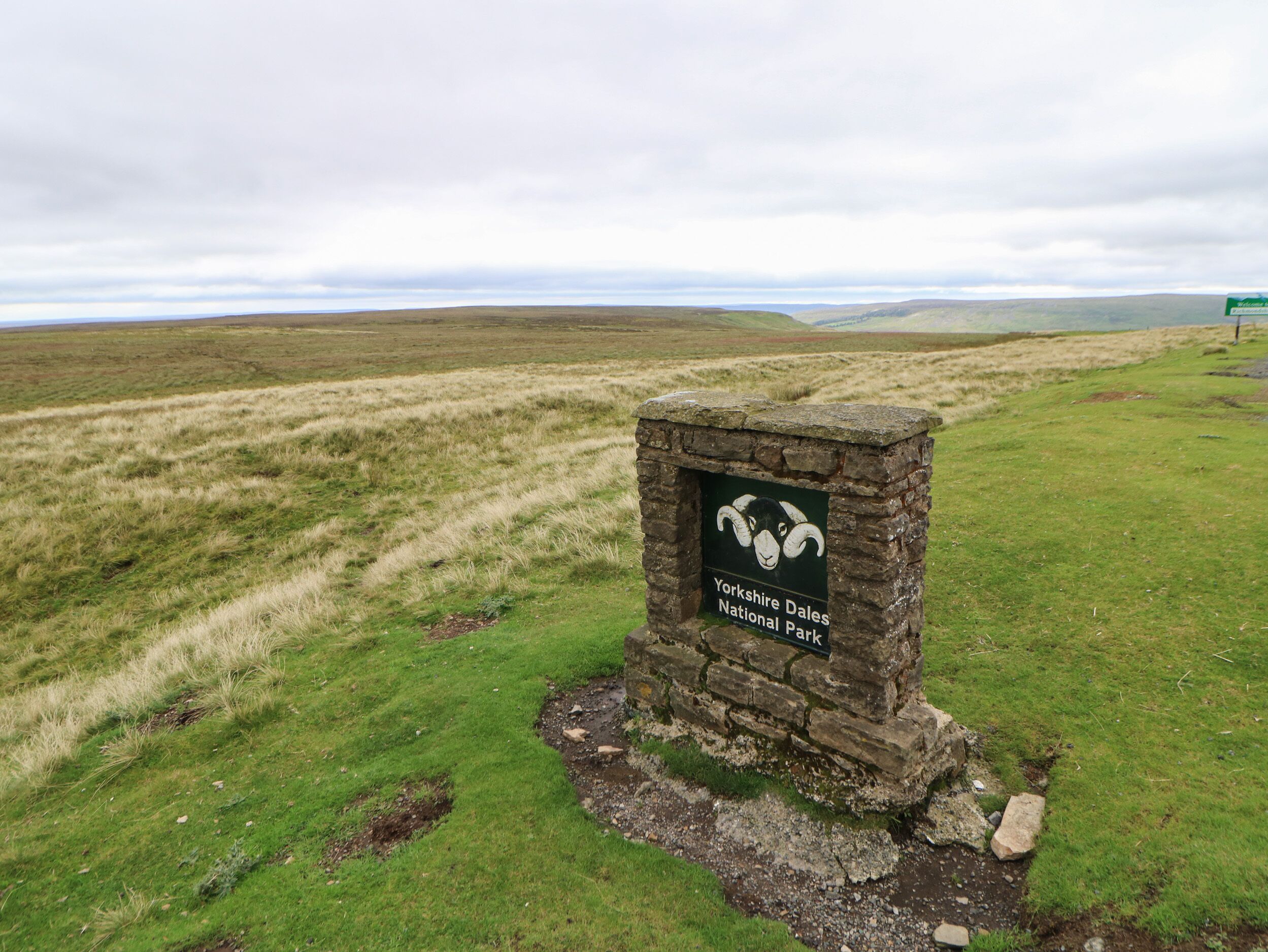 A stone sign with a ram's head and text indicating Yorkshire Dales National Park.