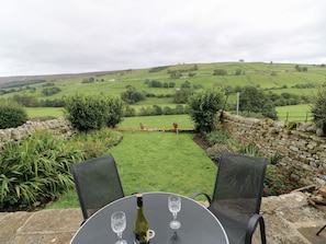 A table with a bottle of wine and two glasses, set against a scenic hillside view. - Cowlings (Richmond)