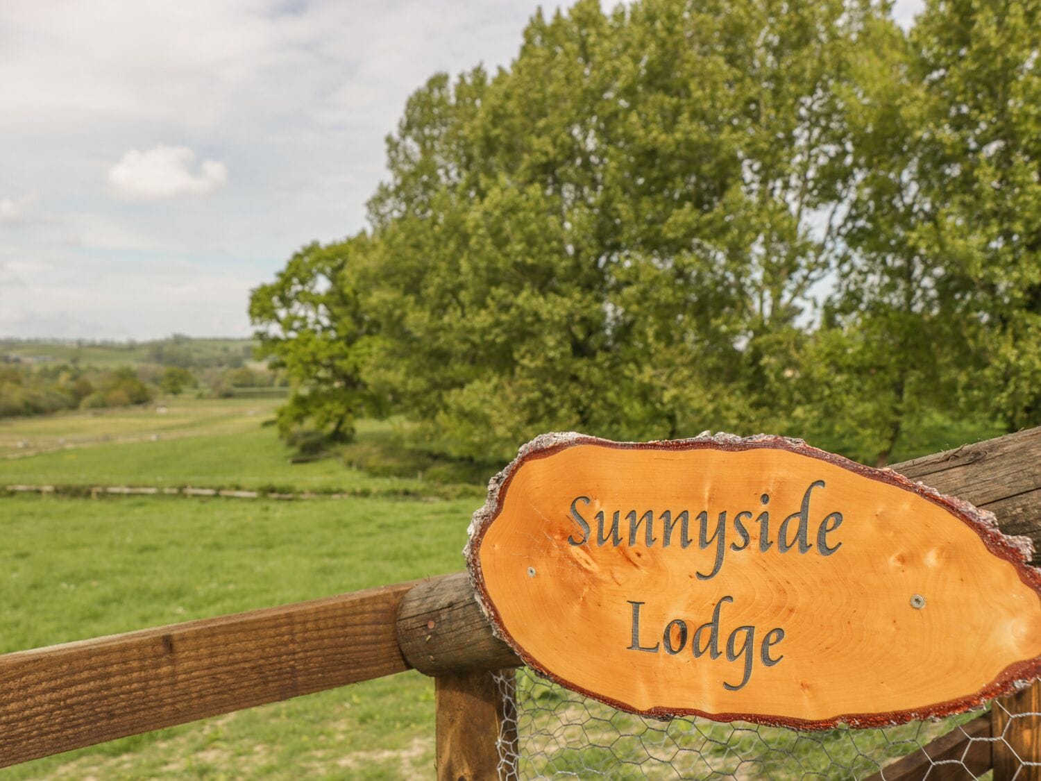 Une enseigne en bois portant l’inscription « Sunnyside Lodge », qui indique le nom de l’établissement.