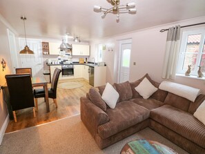 Cozy living space with a kitchenette, sofa, dining table, and small rug.