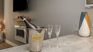 Una cocina moderna con un cubo para champán, dos copas y un florero decorativo sobre la encimera.