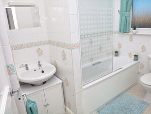 Et badeværelse med vask, badekar og toilet.