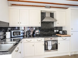 Equipped with a microwave, coffee maker, toaster, and oven, this kitchen offers a clean and minimalist design.