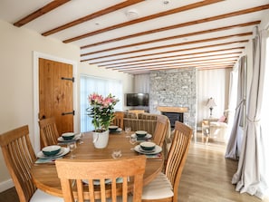 Enjoy meals in this inviting dining area with a round table for six, stone fireplace, and comfortable seating.