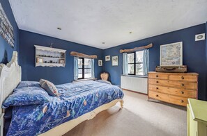 A bedroom with a bed, dresser, and a map on the wall.