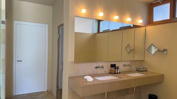 A bathroom with two sinks, a large mirror, and a door.