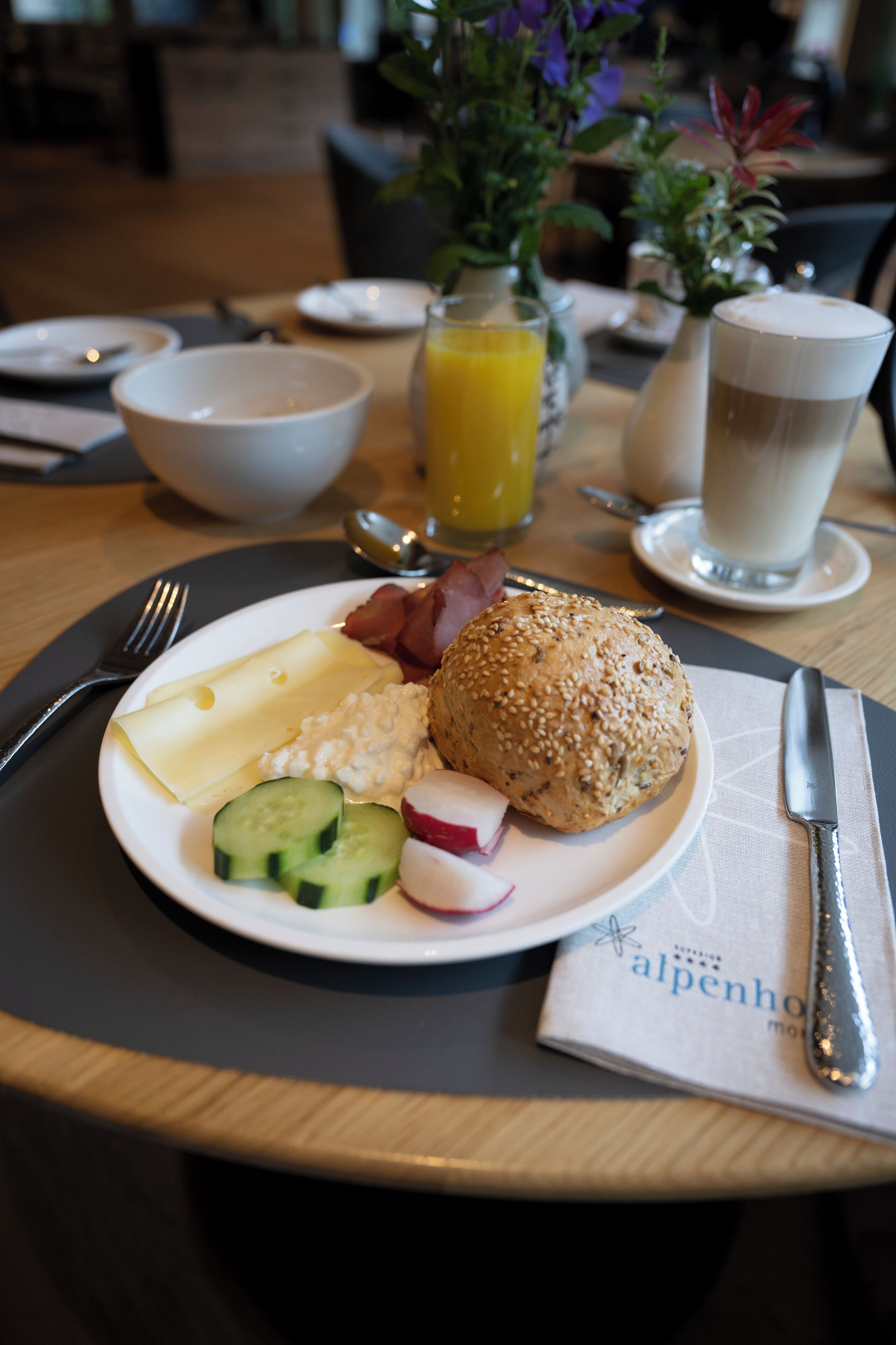 A breakfast setting with a plate of food, a glass of orange juice, and a cup of coffee.