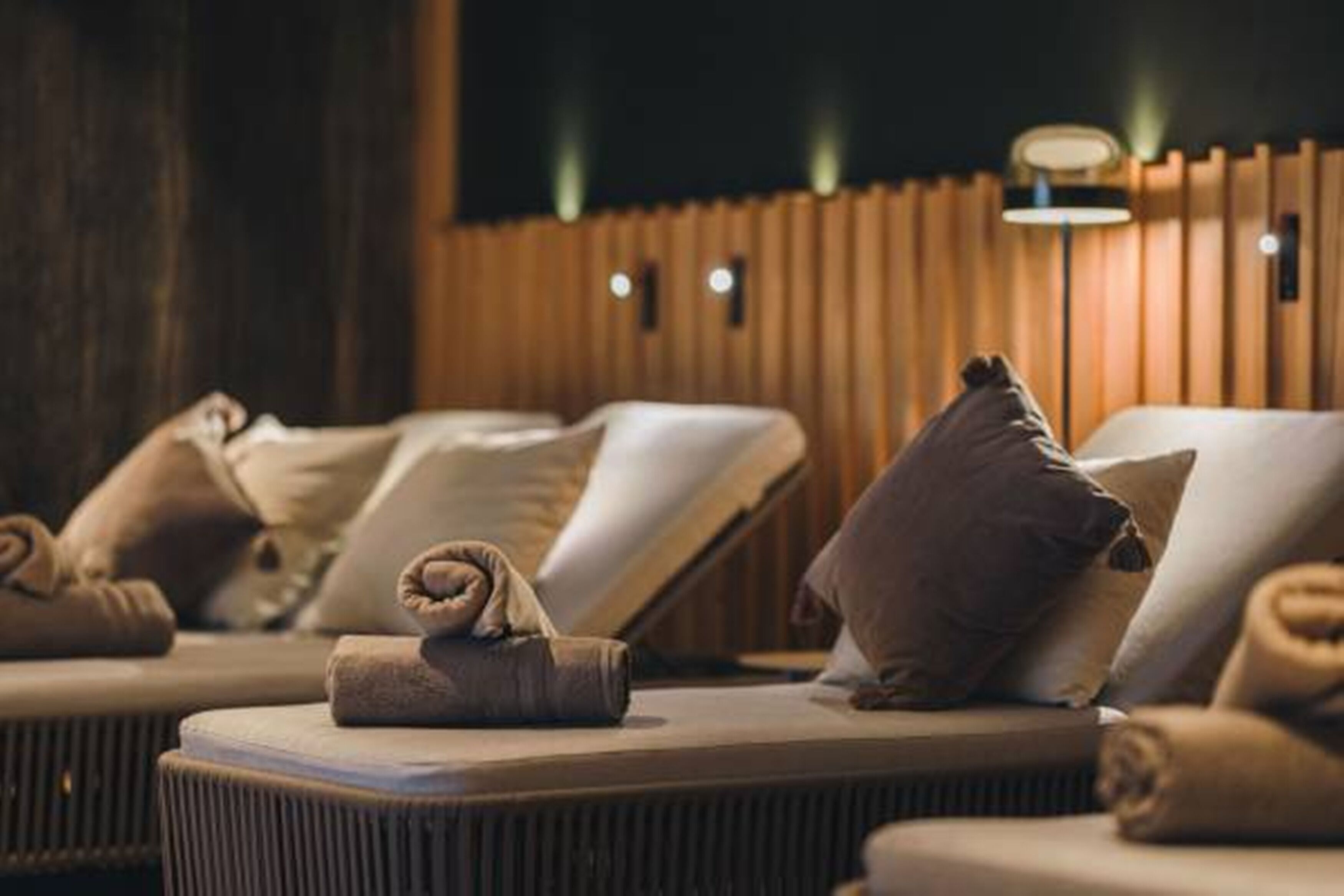 A spa room with multiple massage chairs, each with a towel and pillow.