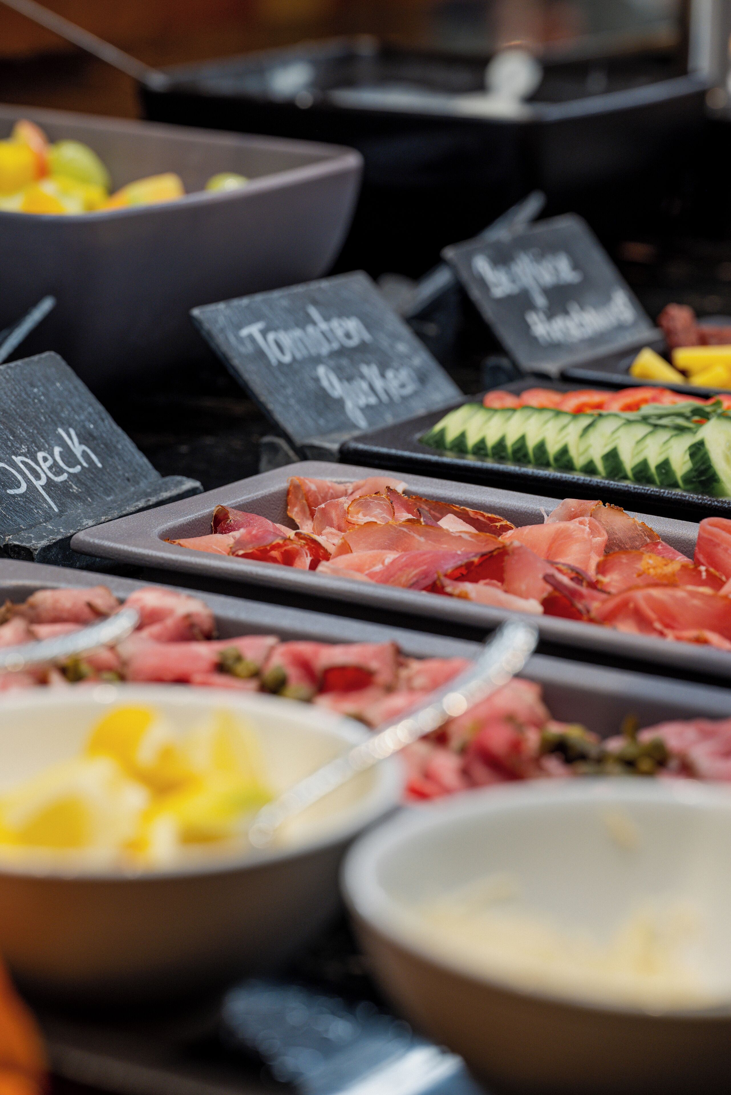 A buffet with various food options including meats, vegetables, and fruits.