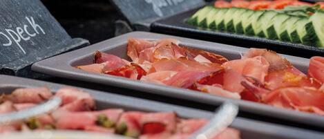 A buffet with various food options including meats, vegetables, and fruits.